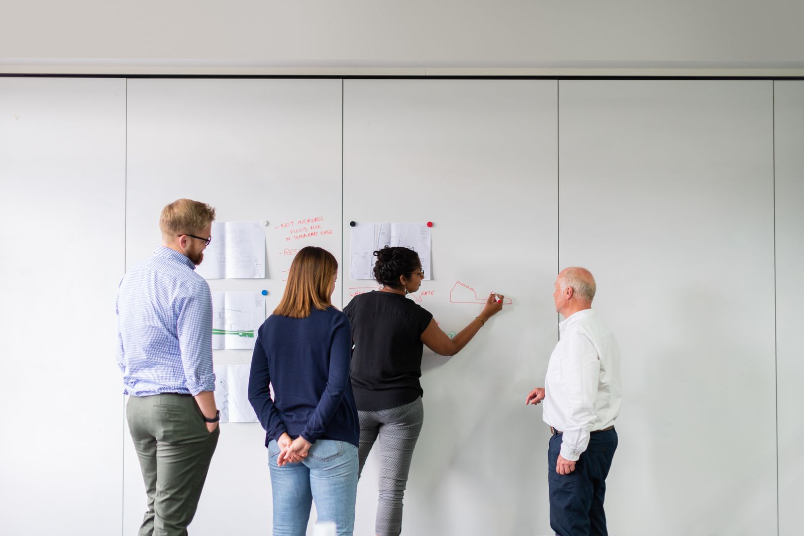 A team sketching ideas together on a whiteboard